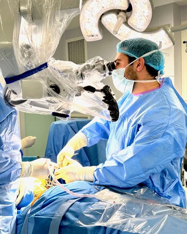 Dr. Rafael Portela a realizar cirurgia minimamente invasiva da coluna com suporte de microscópio cirúrgico de alta precisão.